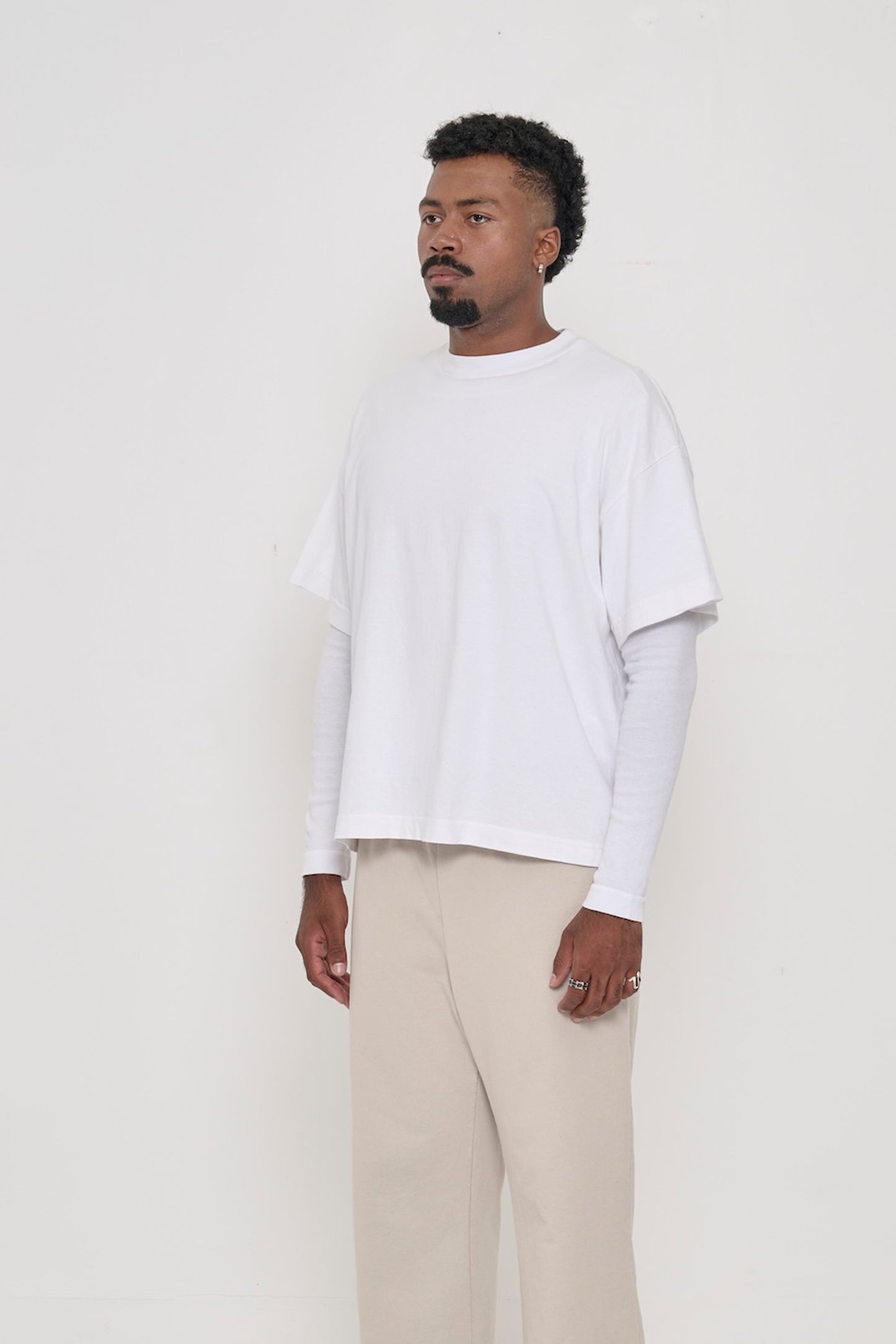 3/4 front view of a man wearing White Heavyweight Boxier Trash Tee showing no side seams.