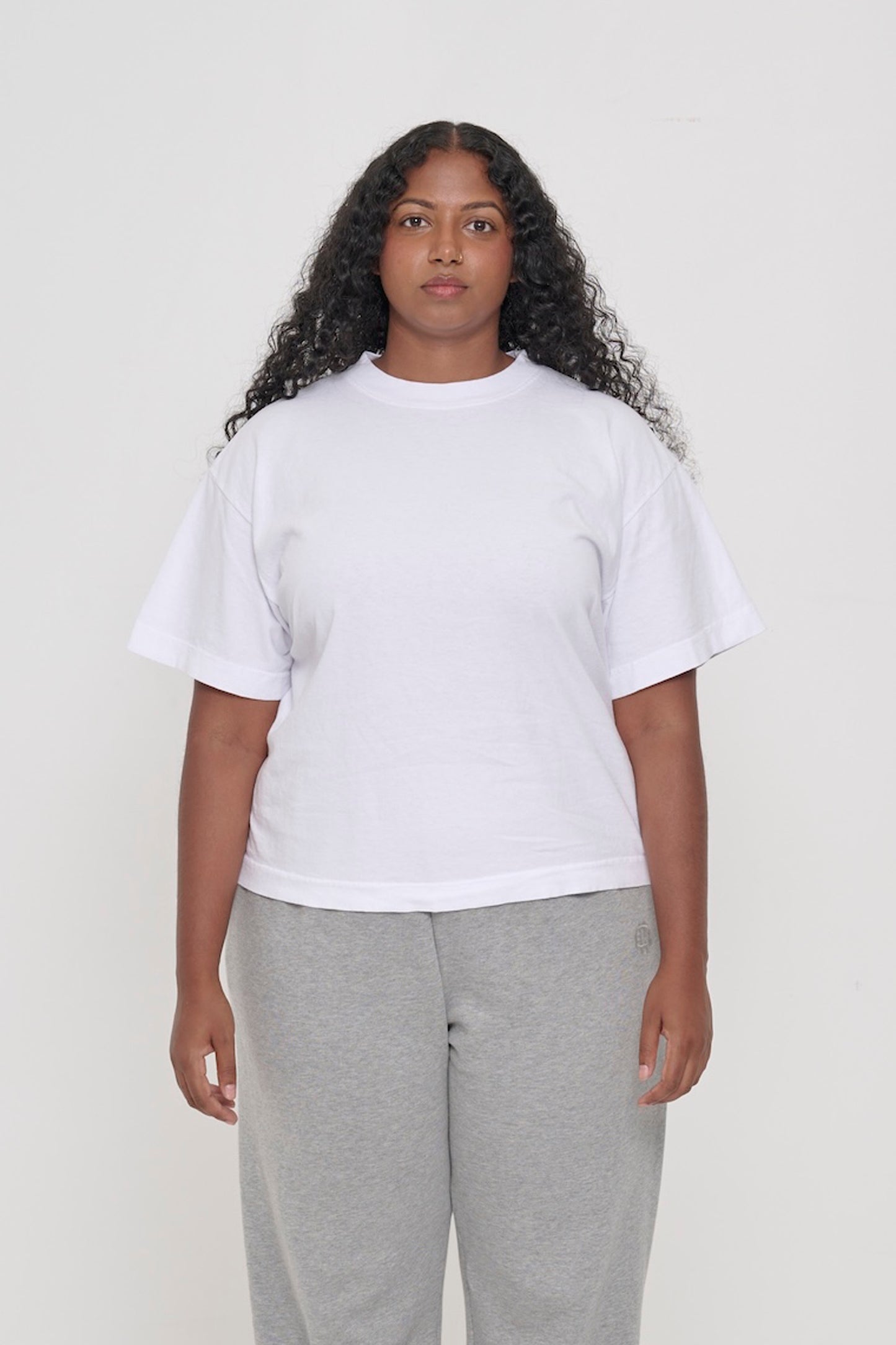 A 5'8" tall woman wearing White Heavyweight Boxier Trash Tee in size L. Hem is at her upper middle hip.