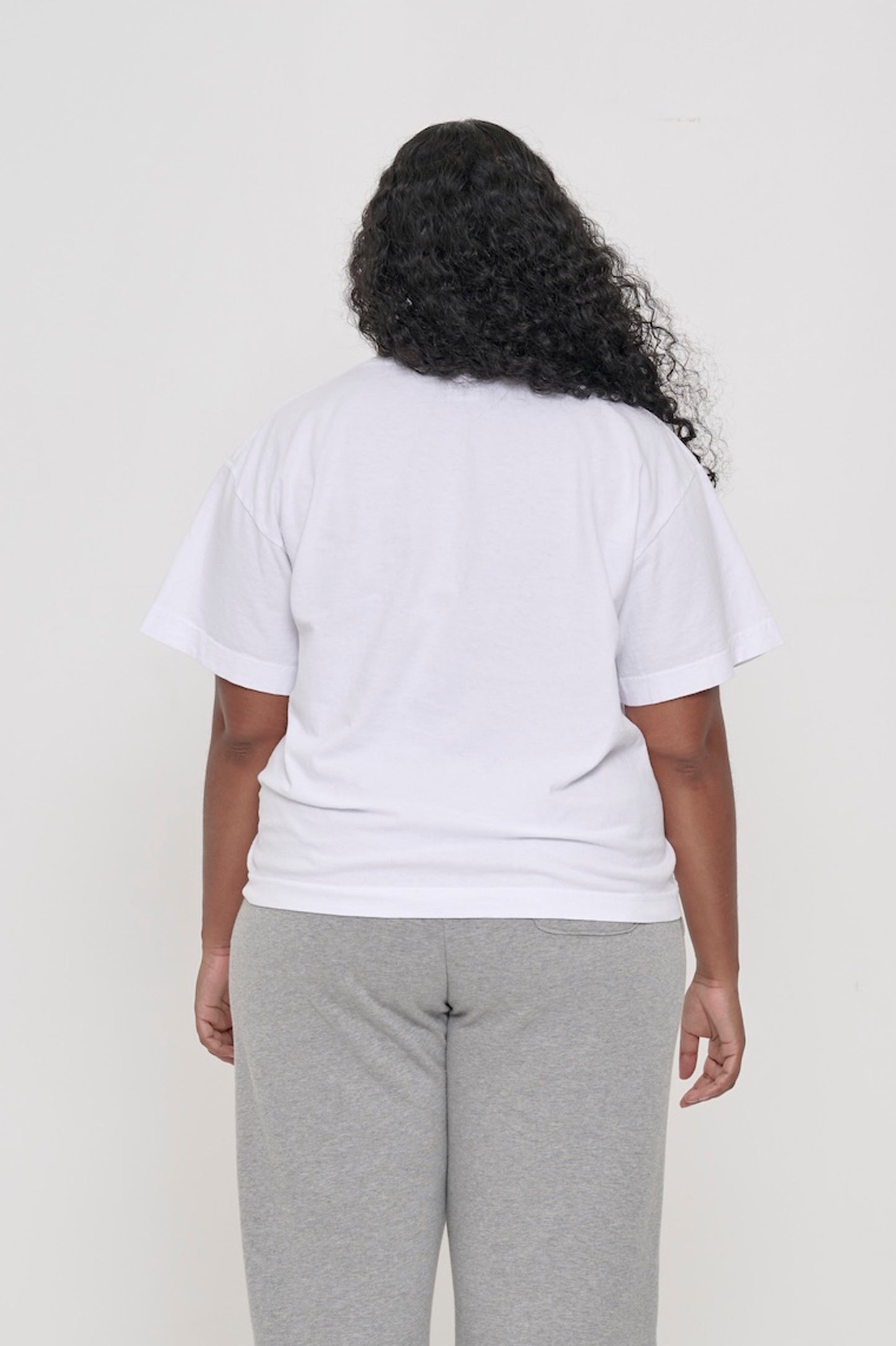 Back view of a woman wearing White Heavyweight Boxier Trash Tee showing fabric drape.