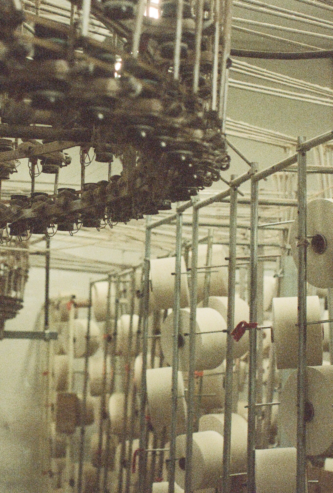 Spools of 100% Reclaimed Waste Cotton yarn inside our Los Angeles factory before being knit