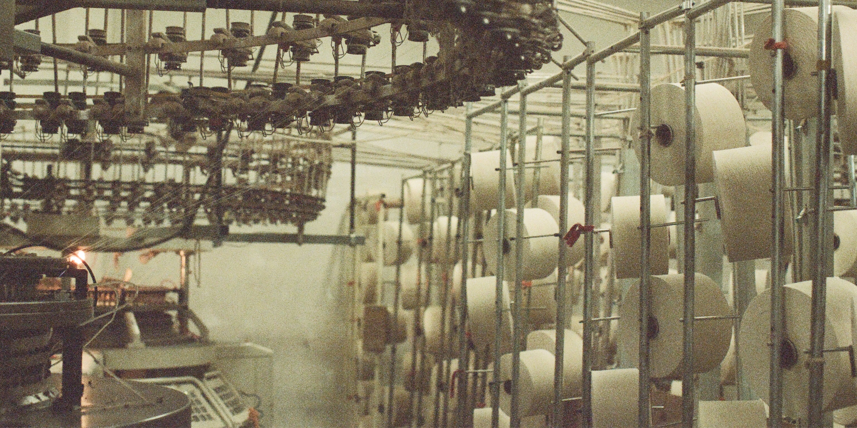 Spools of 100% Reclaimed Waste Cotton yarn inside our Los Angeles factory before being knit