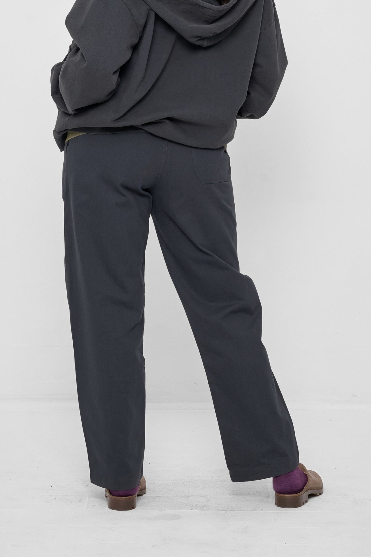 Life Uniform Pants in Slate – back view, model's hands in hoodie front pocket
