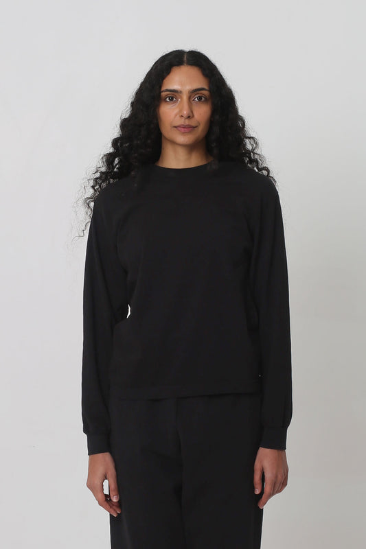 5'10" woman in an XS Black Long Sleeve Boxier Trash Tee. Hem's at her upper-middle hip.