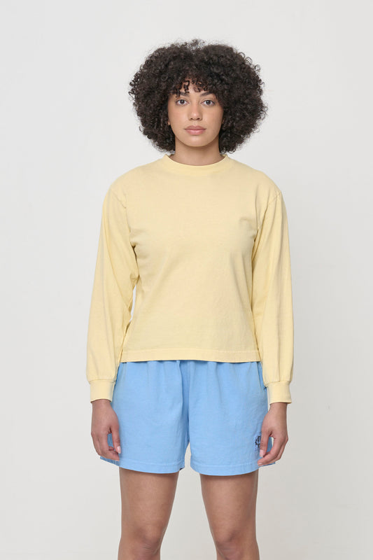 A 5'8" woman wearing a French Butter Long Sleeve Boxier Trash Tee. Her arms are straight down at her sides and bottom hem hits her upper-middle hip.