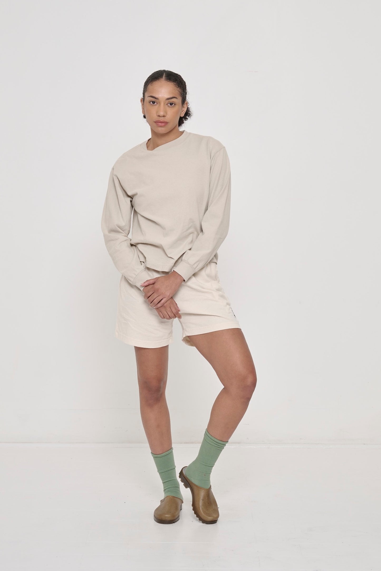Woman in Oat Long Sleeve Boxier Trash Tee paired with Scour Everyday Shorts.