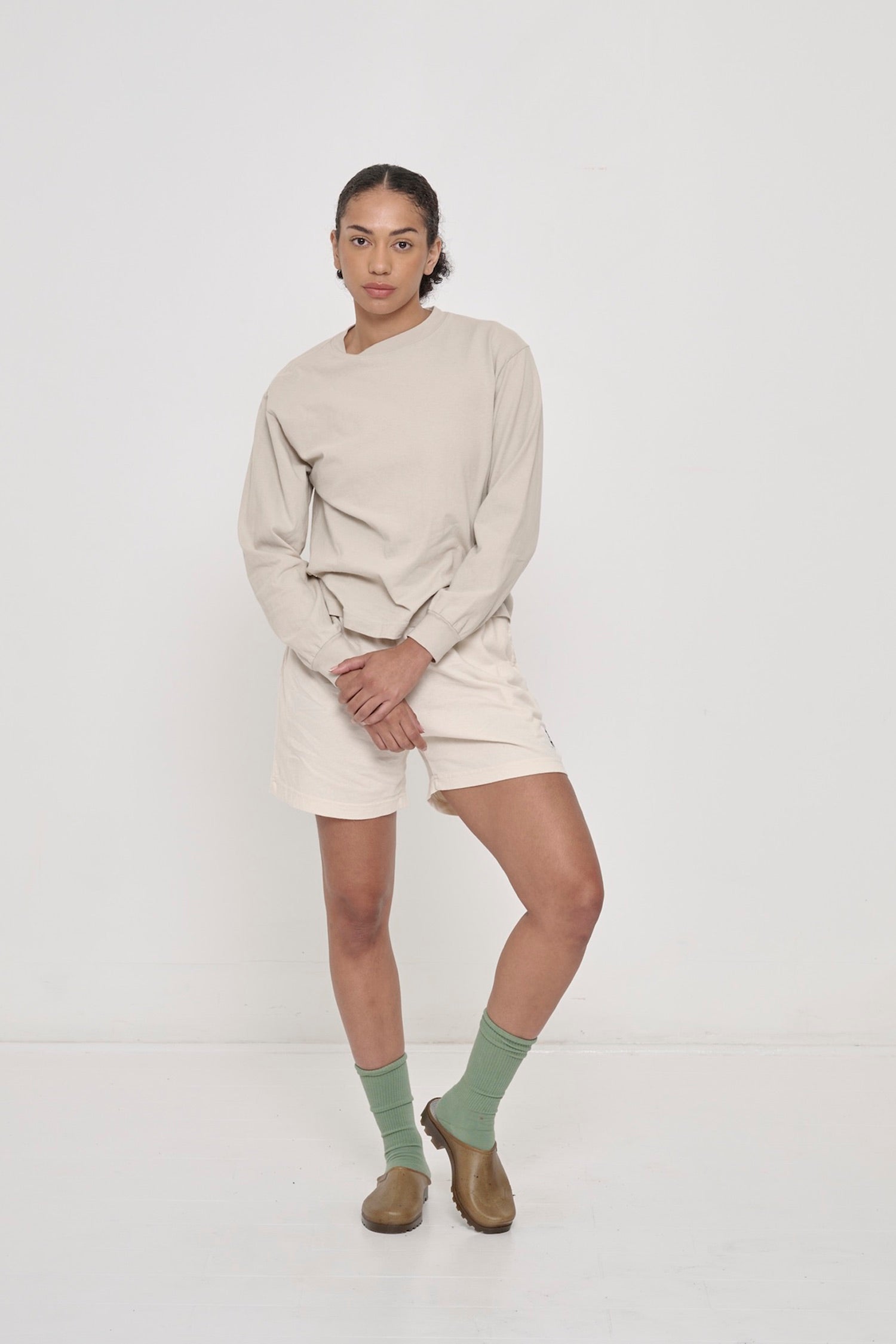 Woman in Oat Long Sleeve Boxier Trash Tee paired with Scour Everyday Shorts.
