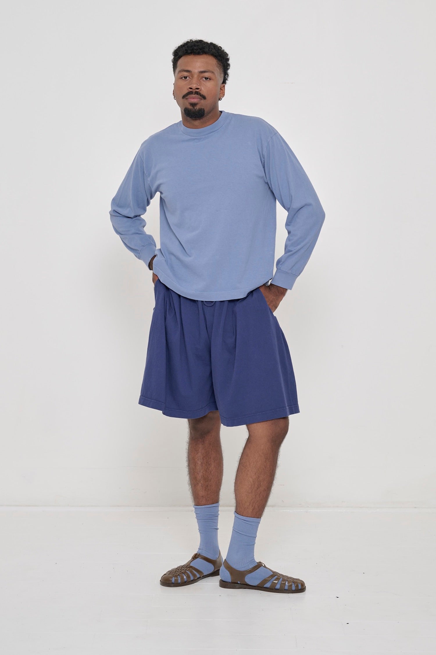 A person wearing Periwinkle Long Sleeve Boxier Trash Tee with Long Tubular Shorts in Washed Navy.