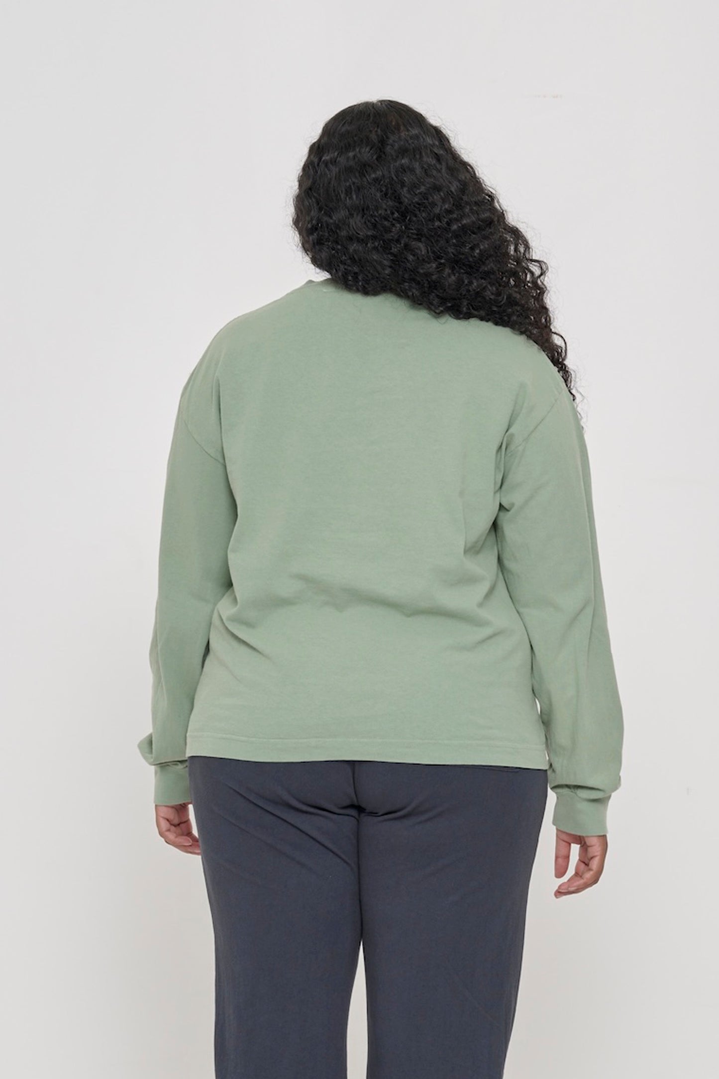 Back view of a person wearing a Wasabi Long Sleeve Boxier Trash Tee showing fabric drape and relaxed fit throughout.