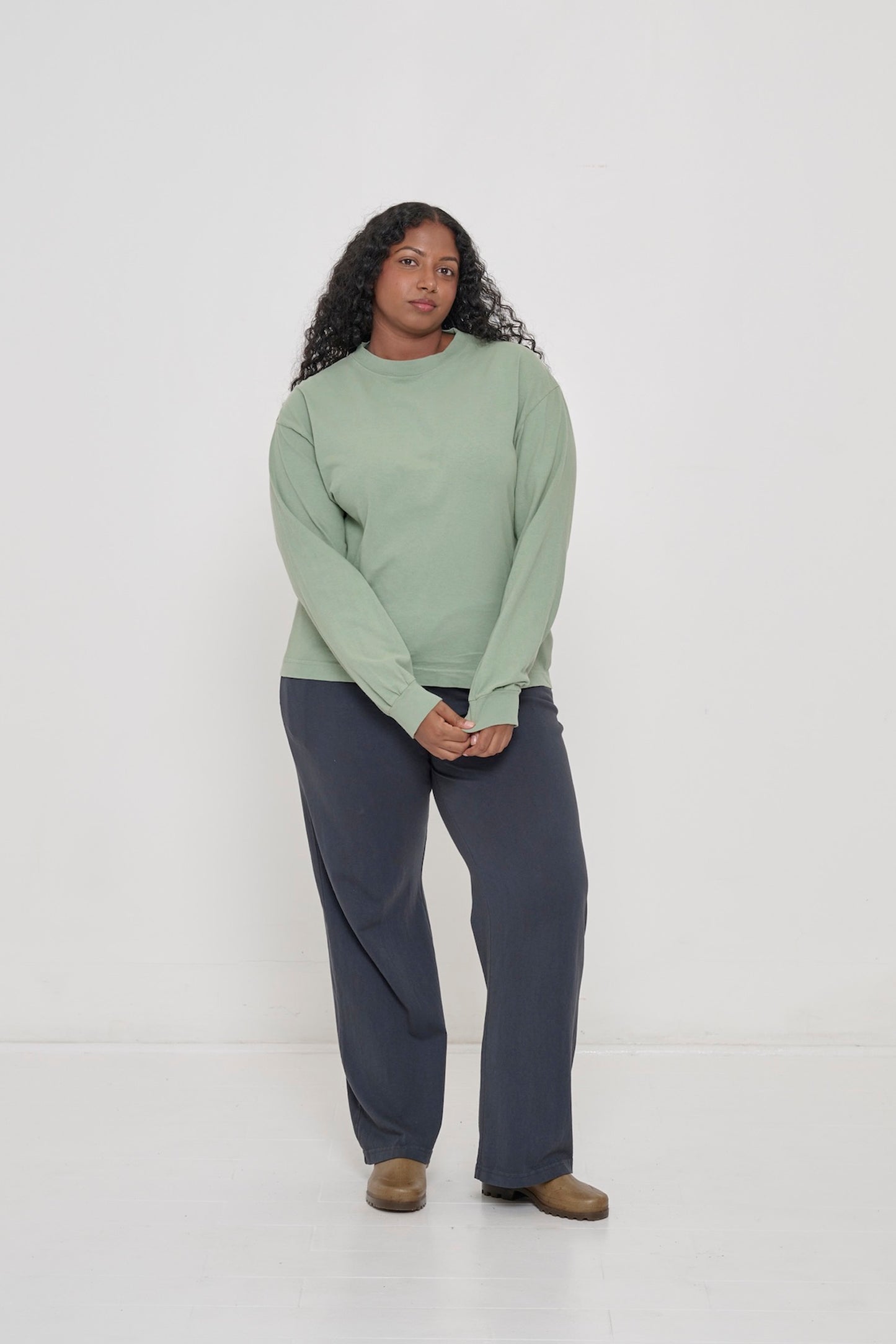 A person wearing Wasabi Long Sleeve Boxier Trash Tee with Slate Apartment Pants and clogs.