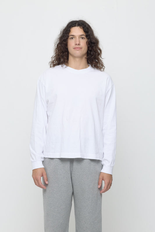 A 6' person in a size M White Long Sleeve Boxier Trash Tee. Hem hits their middle hip.