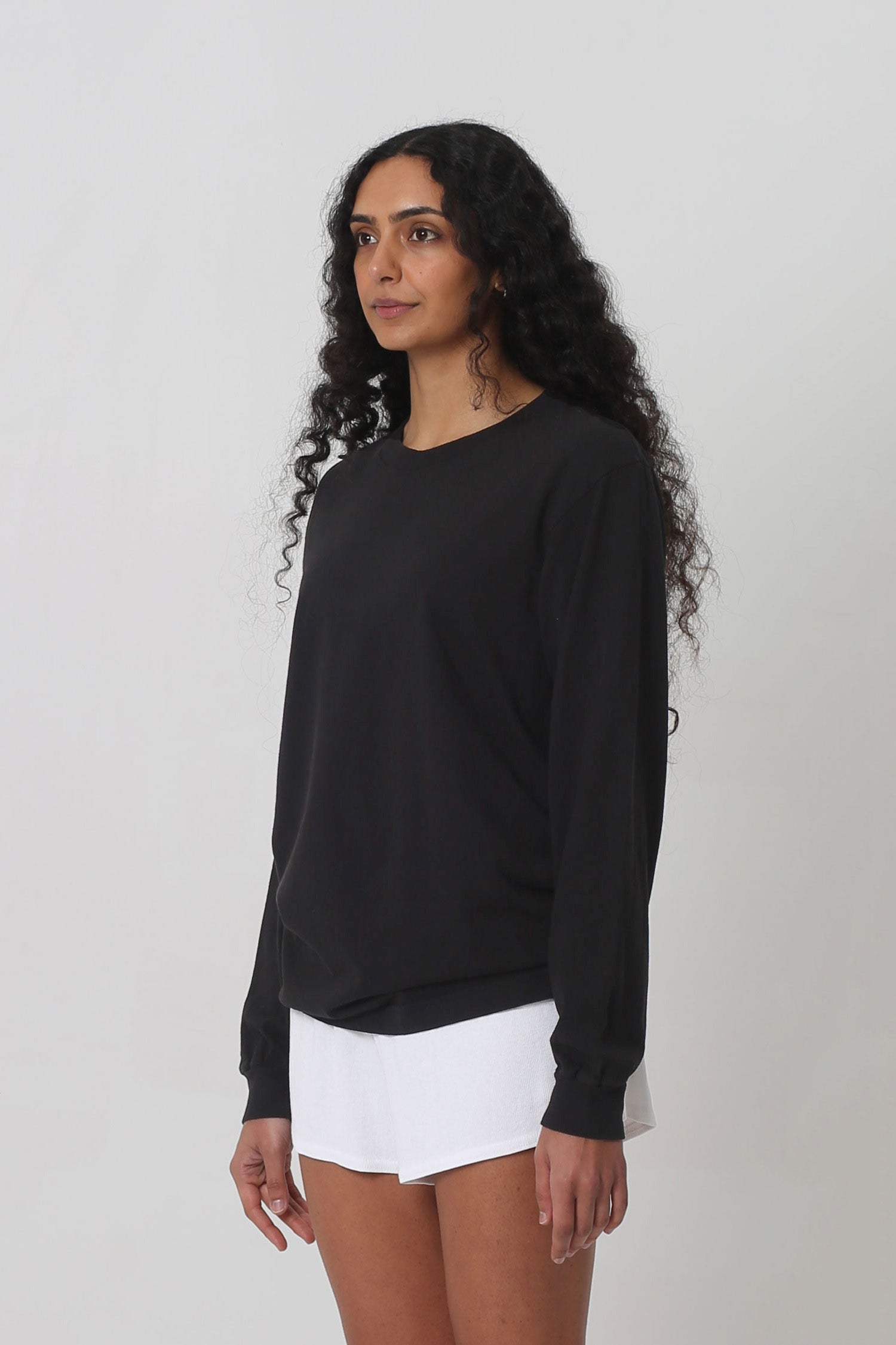 A person turned 45-degrees from the front shows relaxed sleeves and rib cuff.