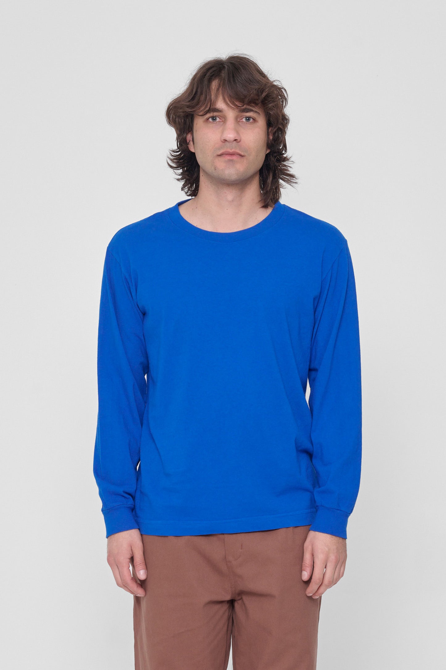 A 6'2" man in a Lapis Long Sleeve Trash Tee in size M. Hem hits just below his hip.
