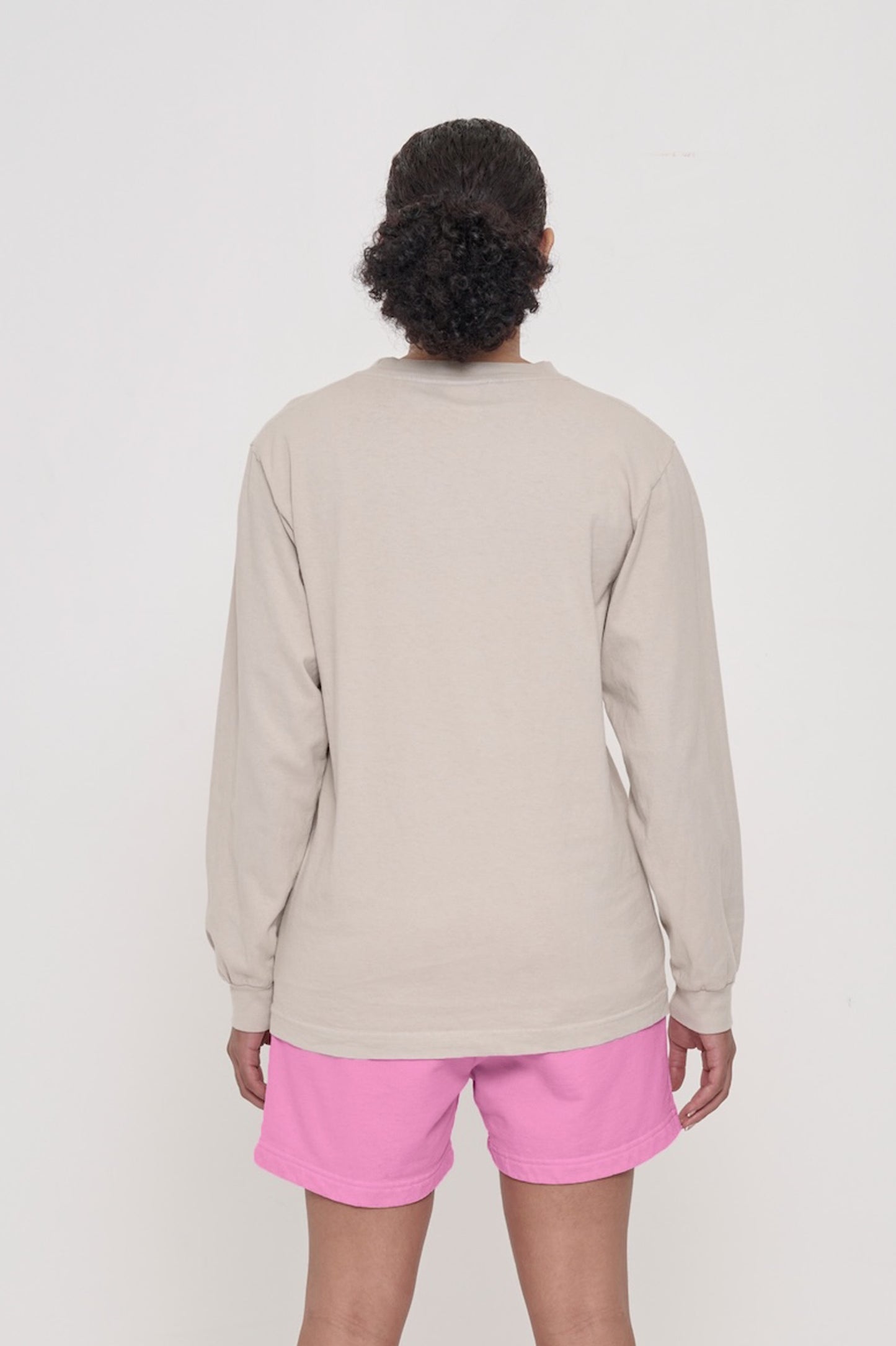 Closeup back view of a person wearing an Oat Long Sleeve Trash Tee, showing fabric drape and relaxed fit throughout.