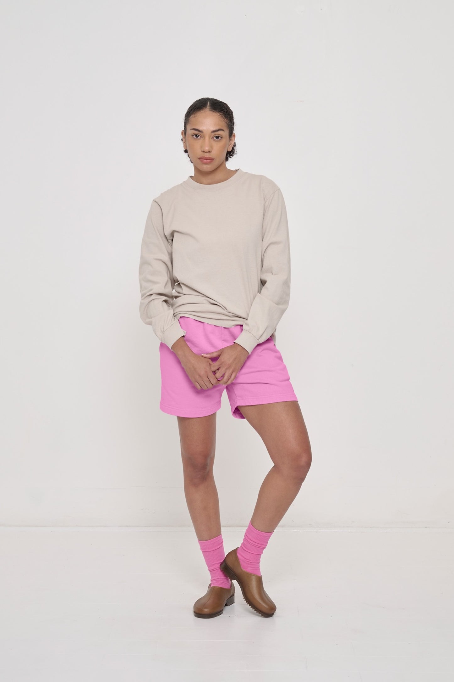 A woman in an Oat Long Sleeve Trash Tee, with Pixie Trash Fleece Everyday Shorts.