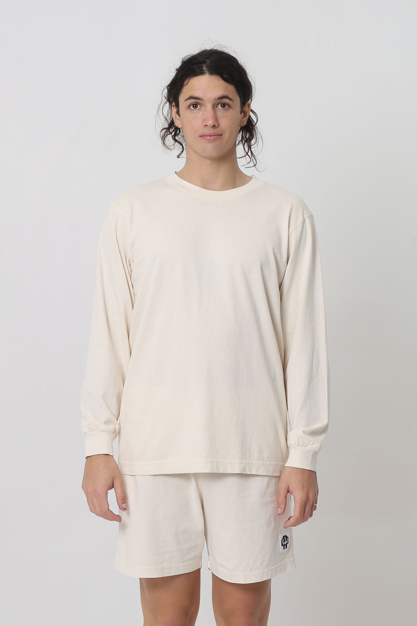 A 6' person in a size M Scour Long Sleeve Trash Tee. Shirt hem hits just below the hip. 