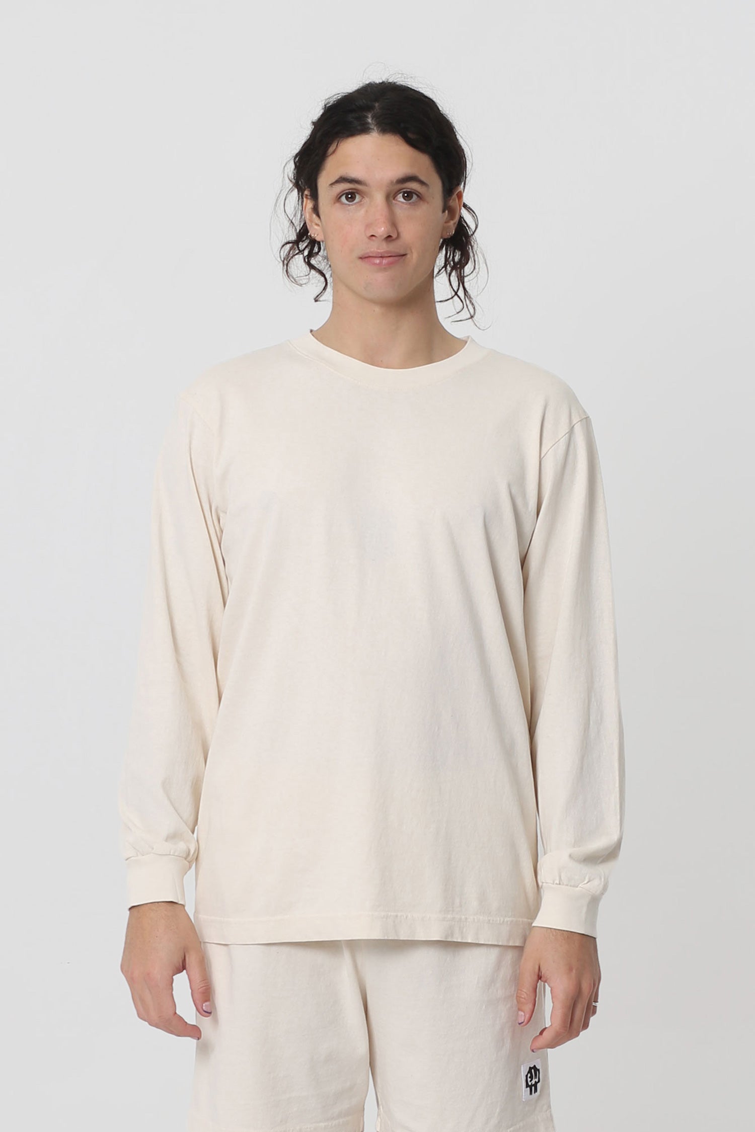 A 6' person in a size M Scour Long Sleeve Trash Tee. Shirt hem hits just below the hip.