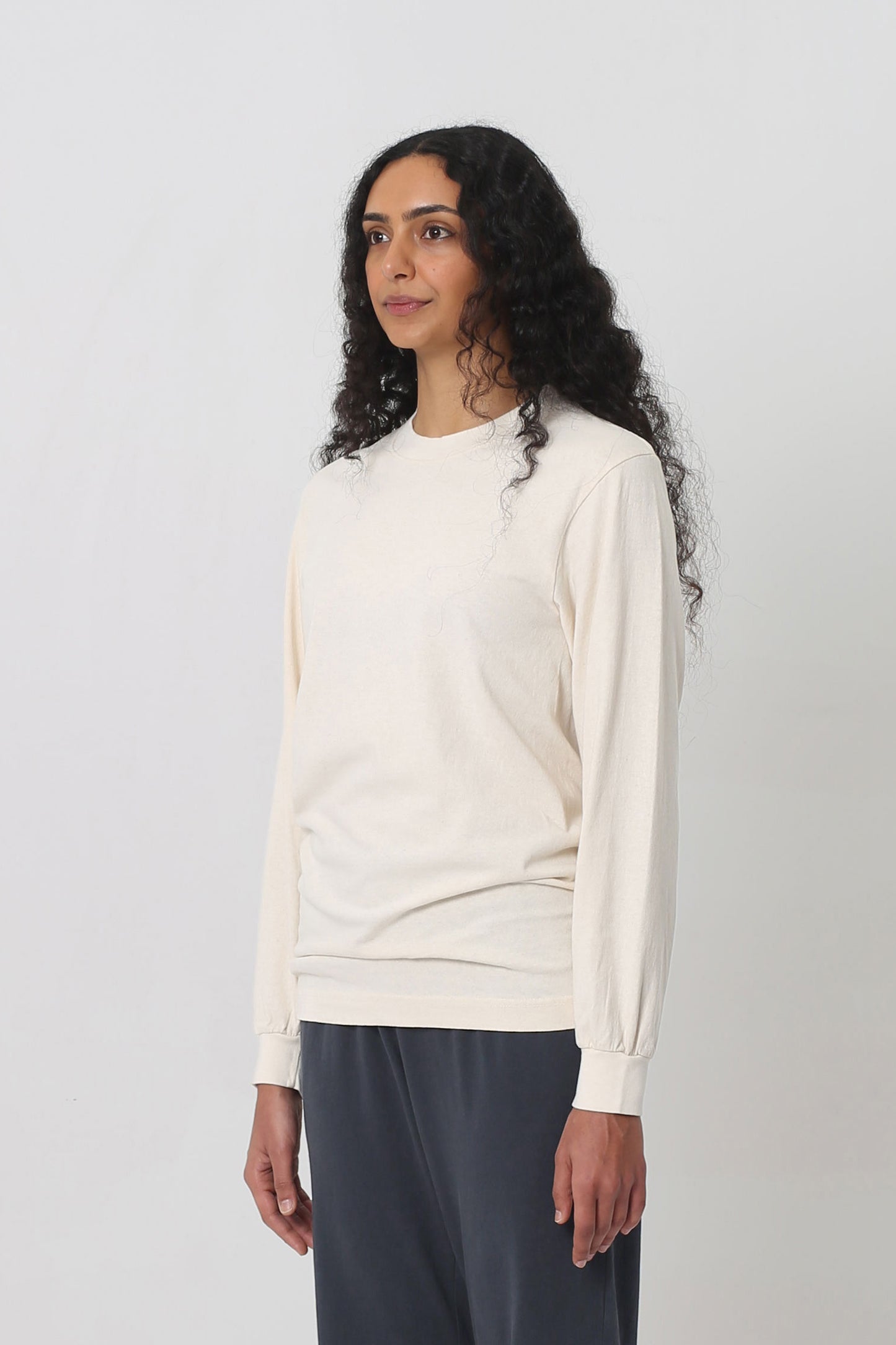A person turned 45-degrees from the front shows relaxed sleeves and rib cuff.