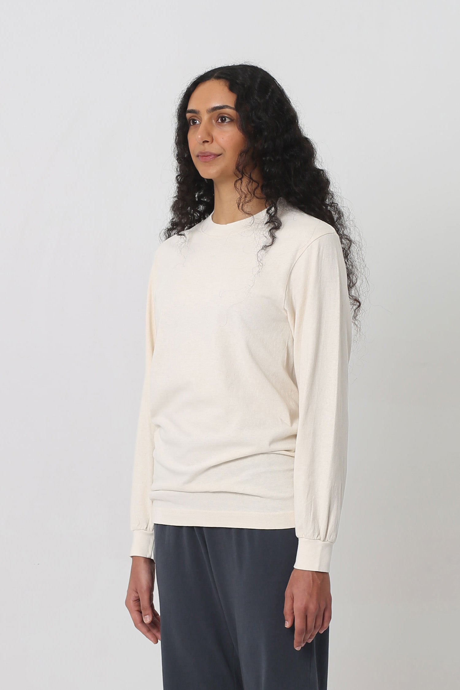 A person turned 45-degrees from the front shows relaxed sleeves and rib cuff.
