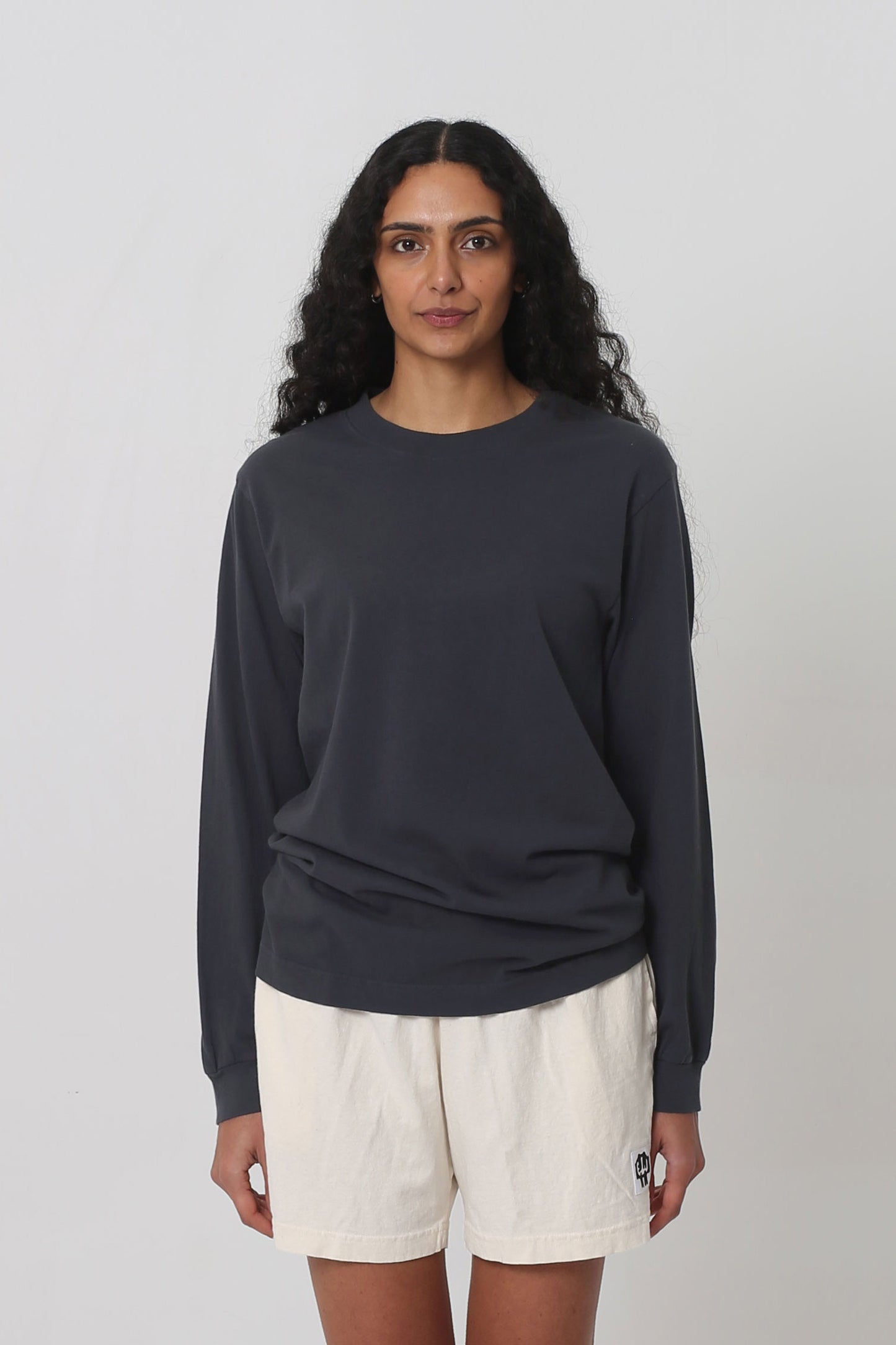 5'10" woman in size S Slate Long Sleeve Trash Tee; shirt hem scrunched up to low hip.