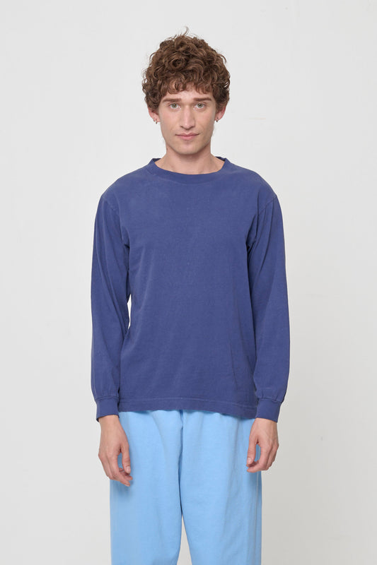 Closeup of a 5'11" person wearing a Washed Navy Long Sleeve Trash Tee in size M. Their arms are straight down at their sides and shirt hem hits the middle-lower hip.