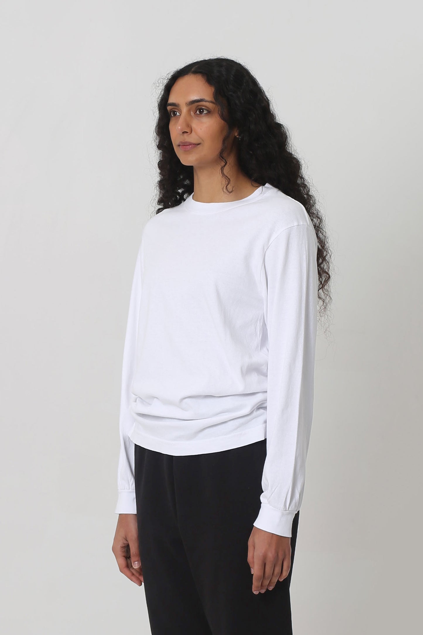 A person turned 45-degrees from the front shows relaxed sleeves and rib cuff.