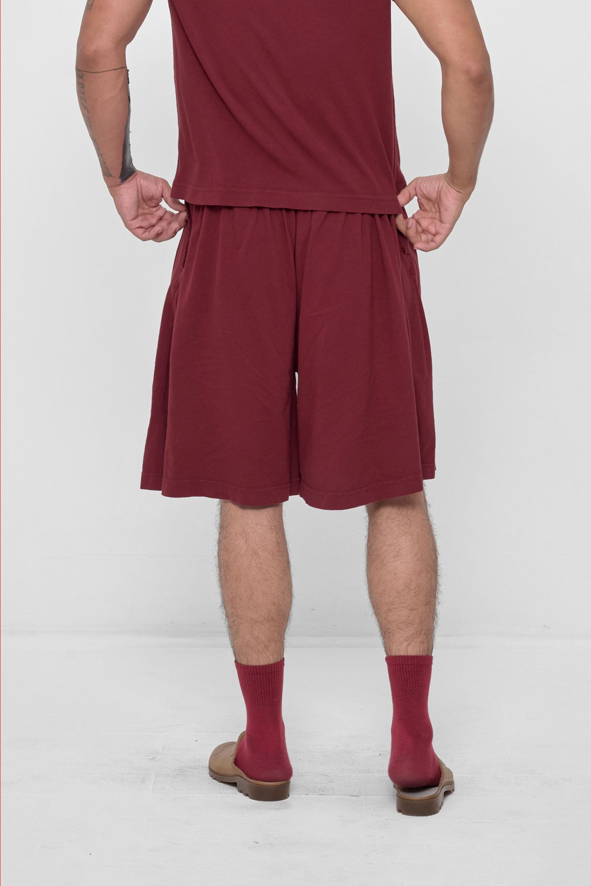 Long Tubular Shorts in Garnet – back view on model