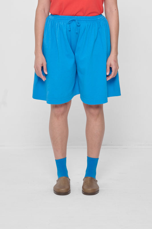 A 5'4" person in Low Rise Malibu Long Tubular Shorts. Hem ends at the knee.