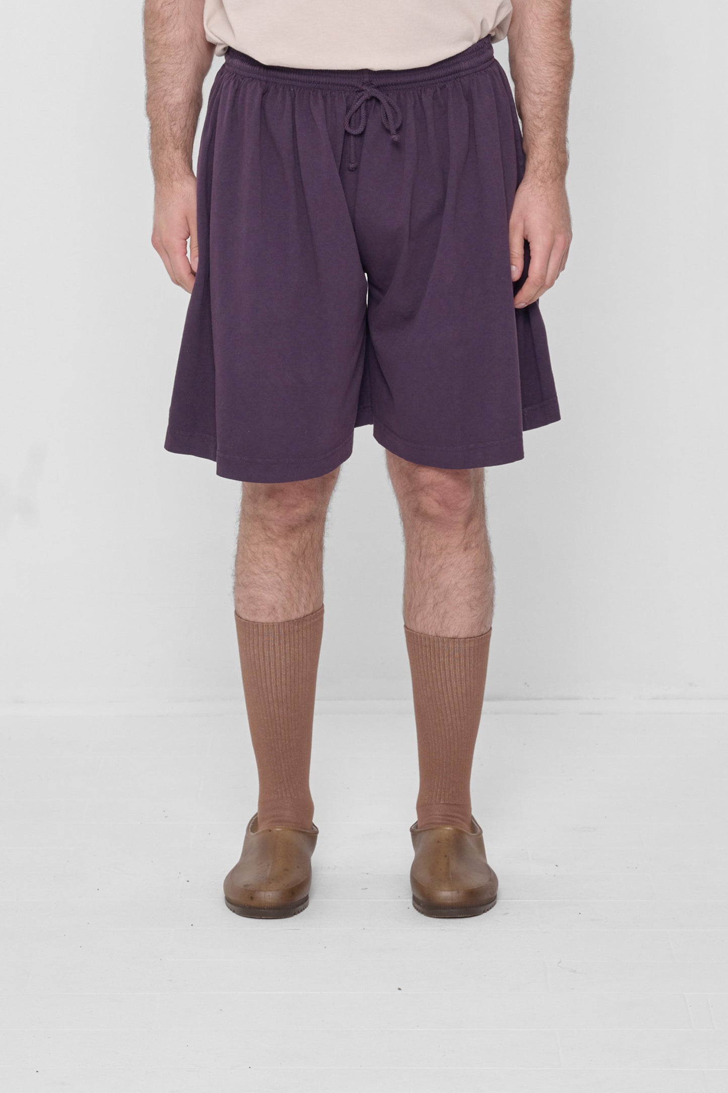 A 6'2" person in Low Rise Mulberry Long Tubular Shorts. Hem ends at the knee.