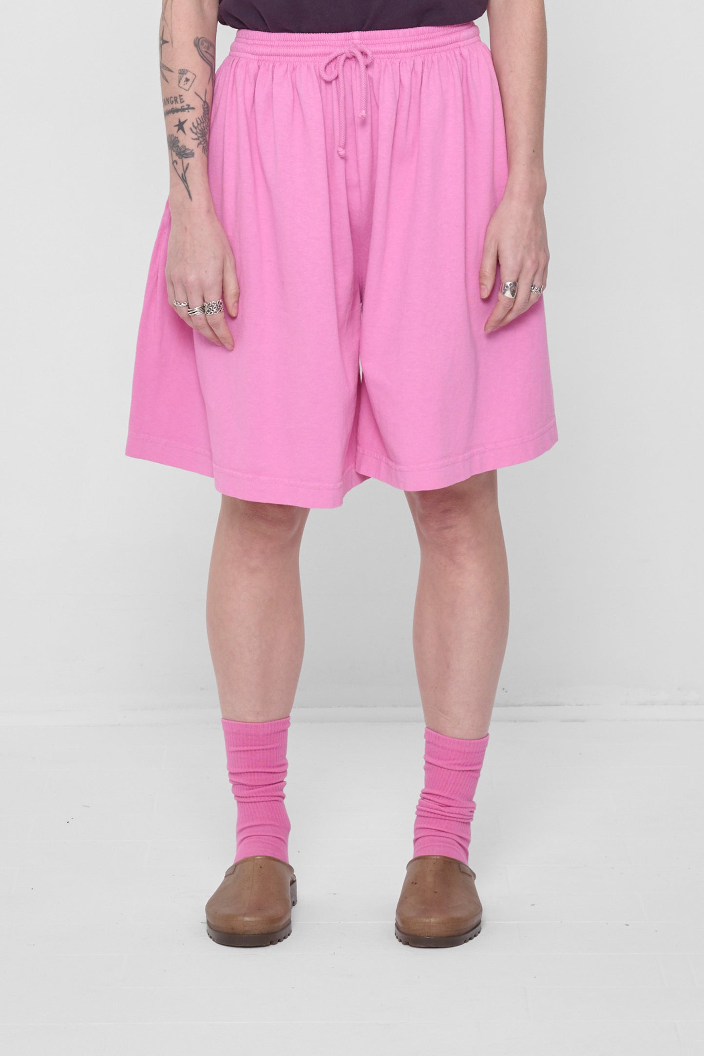 A 5'6" person in Low Rise Pixie Long Tubular Shorts. Hem ends at the knee.