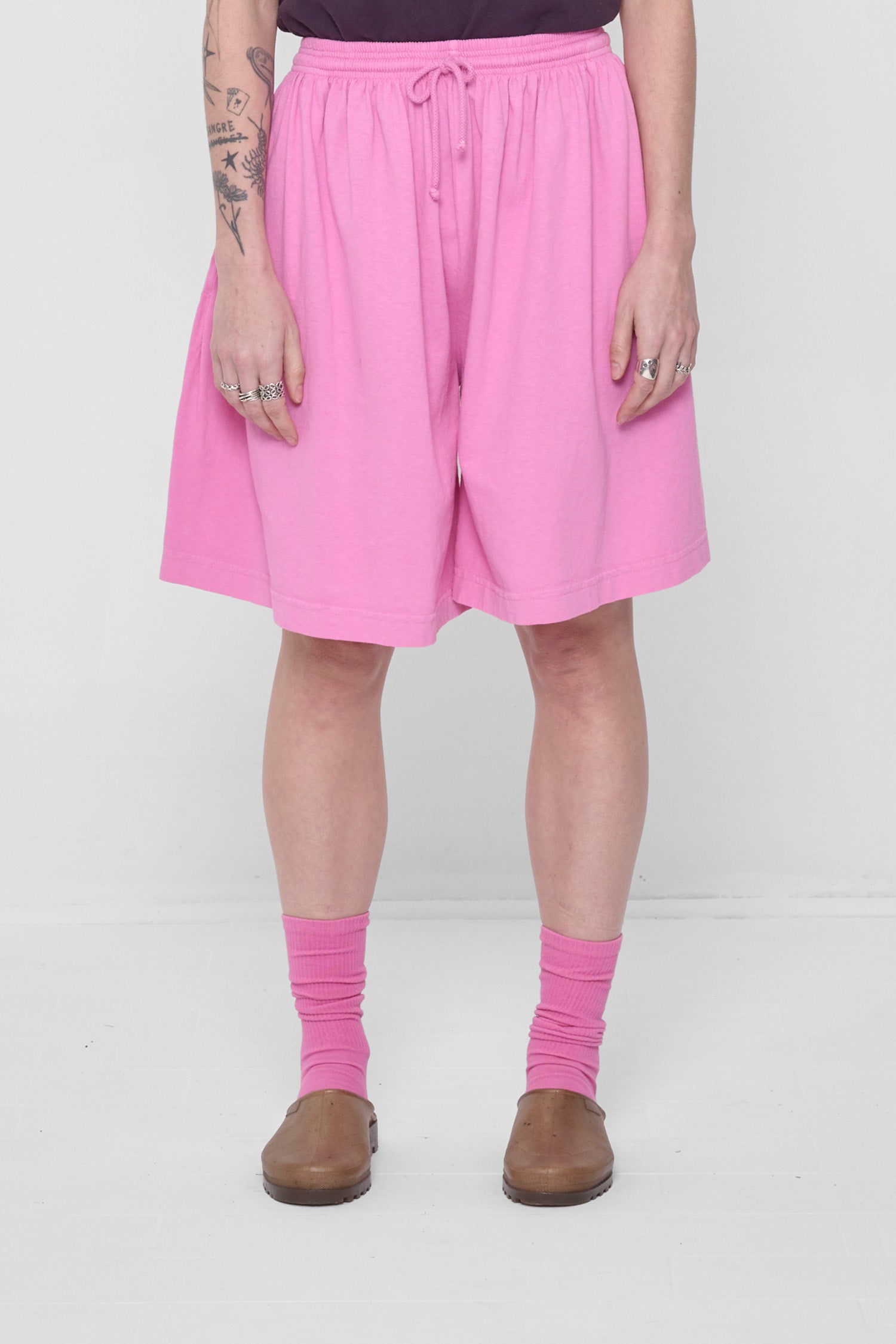 A 5'6" person in Low Rise Pixie Long Tubular Shorts. Hem ends at the knee.