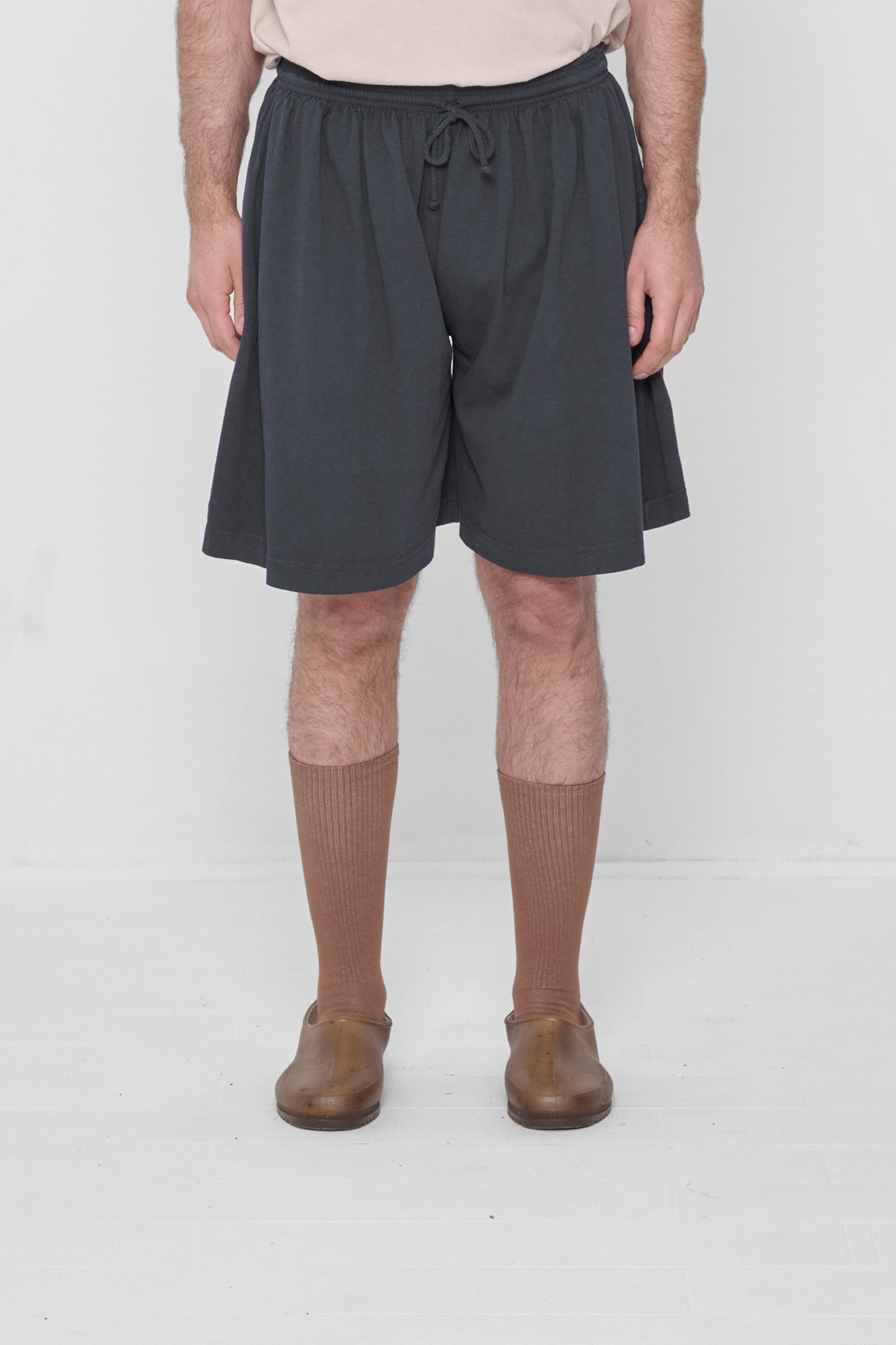 A 6'2" person in Low Rise Slate Long Tubular Shorts. Hem ends at the knee.