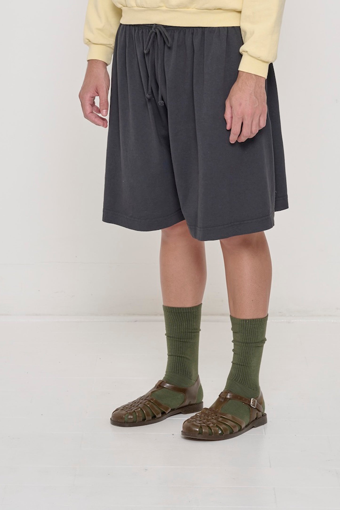Slate Long Tubular Shorts on a person, waist down, 45-degree front angle. Shows no side seams from tubular construction.