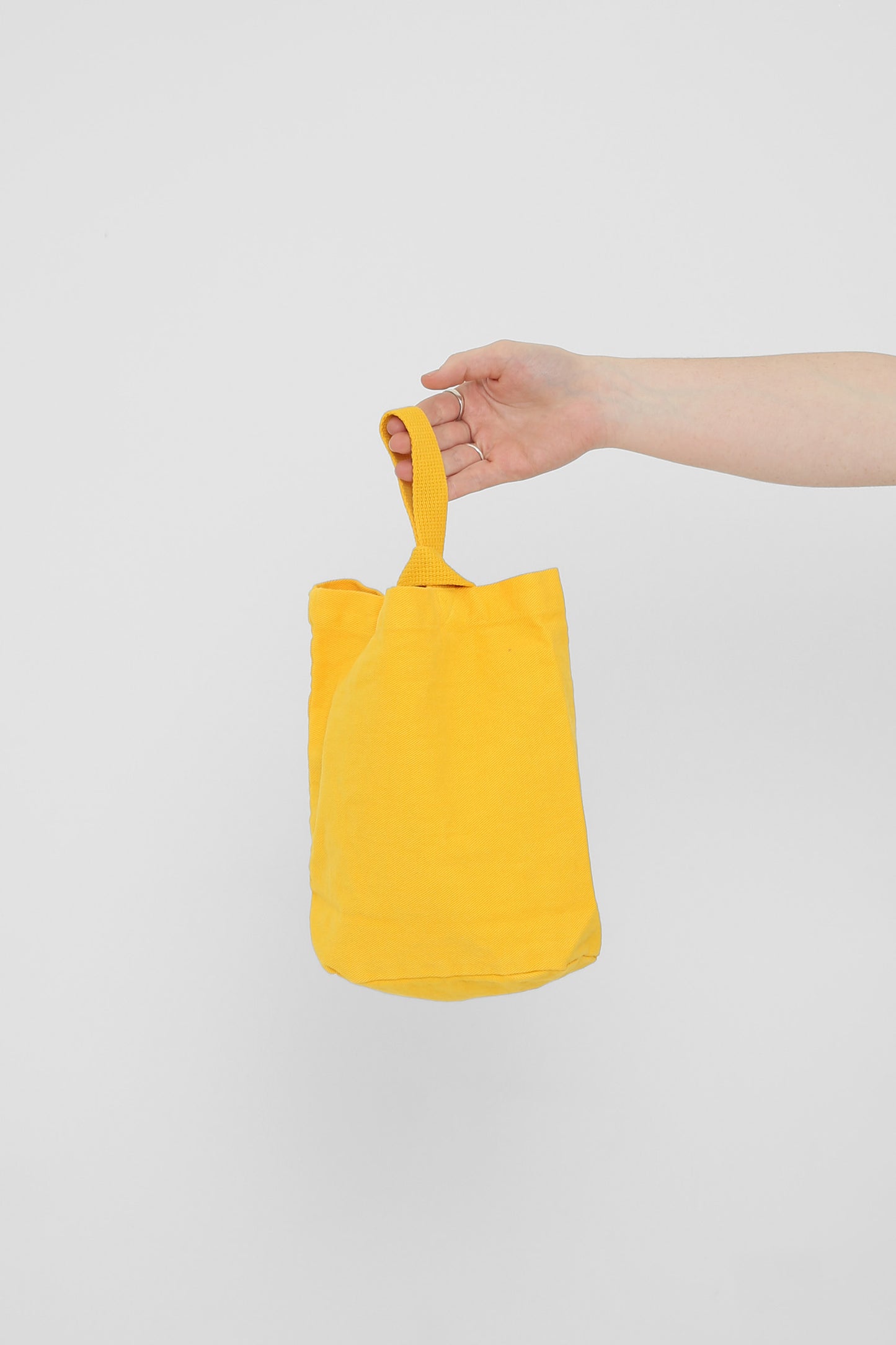 Everybody Yellow Loop Tote: longer strap front-facing, hand-held, showcasing gussets and stitching.