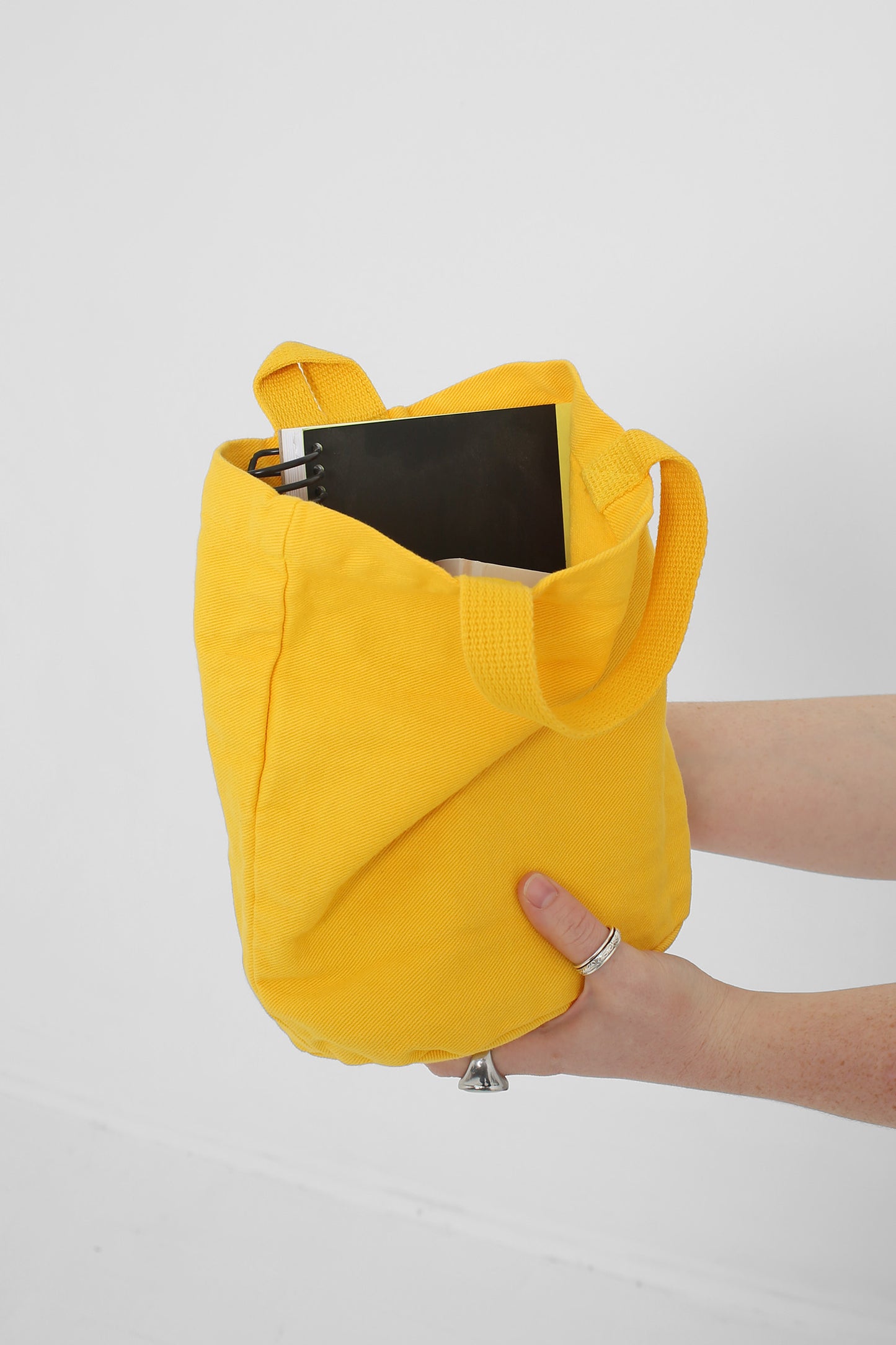 Shown from the side holding a sketchbook with room for more. 