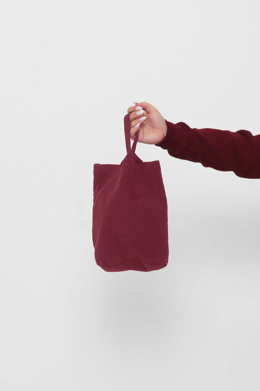Garnet Loop Tote: longer strap front-facing, hand-held, showcasing gussets, depth, and stitching.