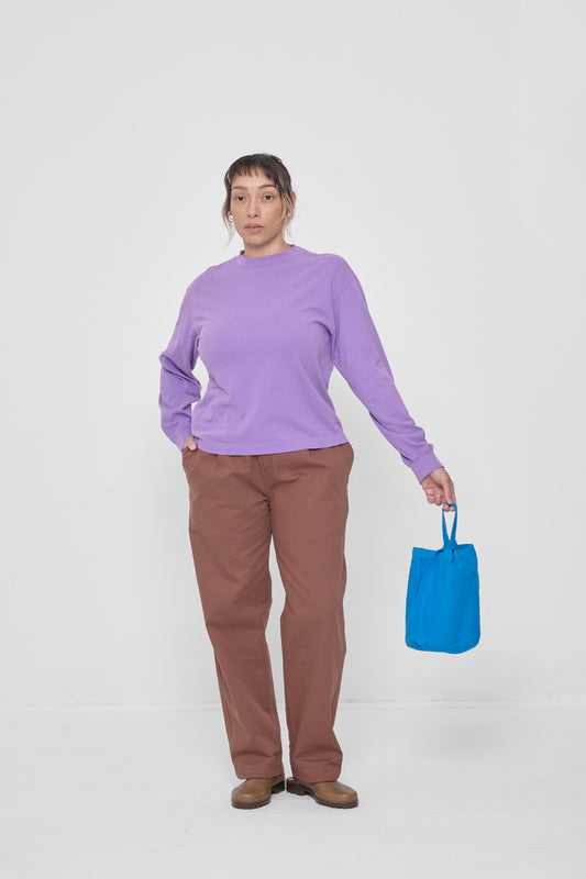 Held by a model who's wearing a Carpe Diem Long Sleeve Boxier Trash Tee.