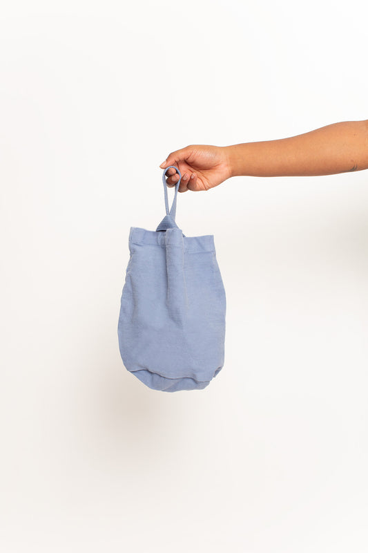 Periwinkle Loop Tote, with shorter strap facing the front, held in a person's hand, shows gussets, depth, stitching.