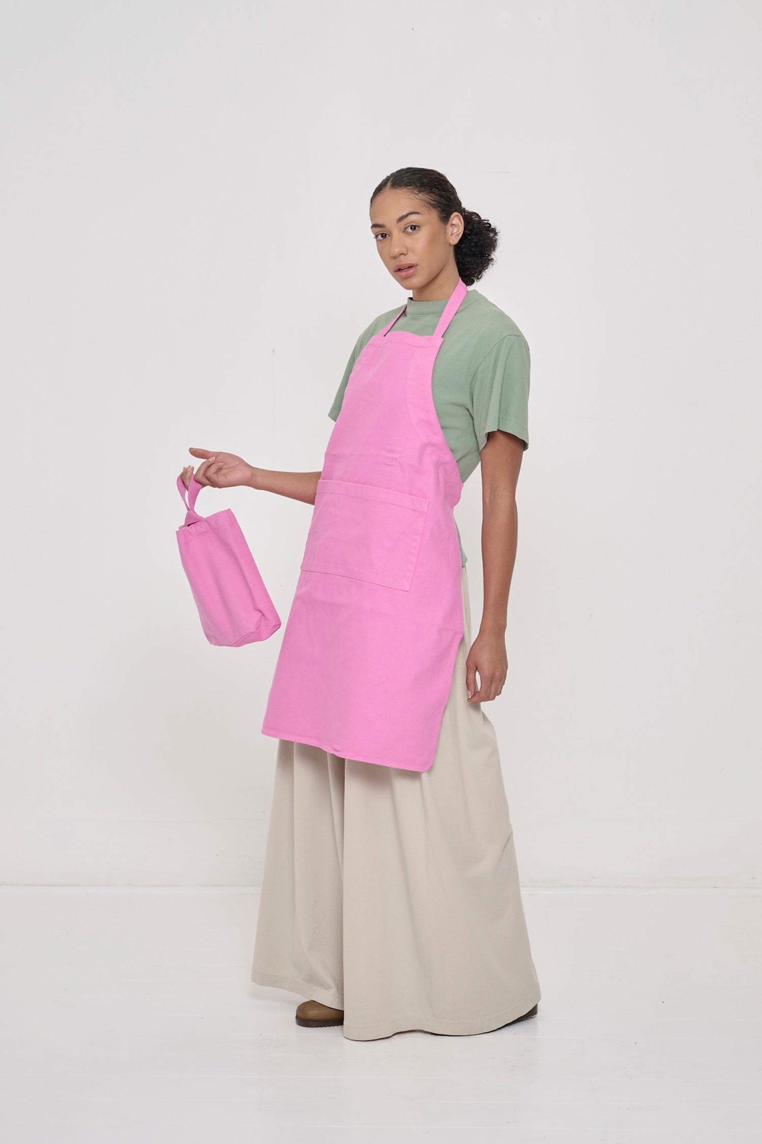Model holding Pixie Loop Tote and wearing Pixie Adjustable Apron.