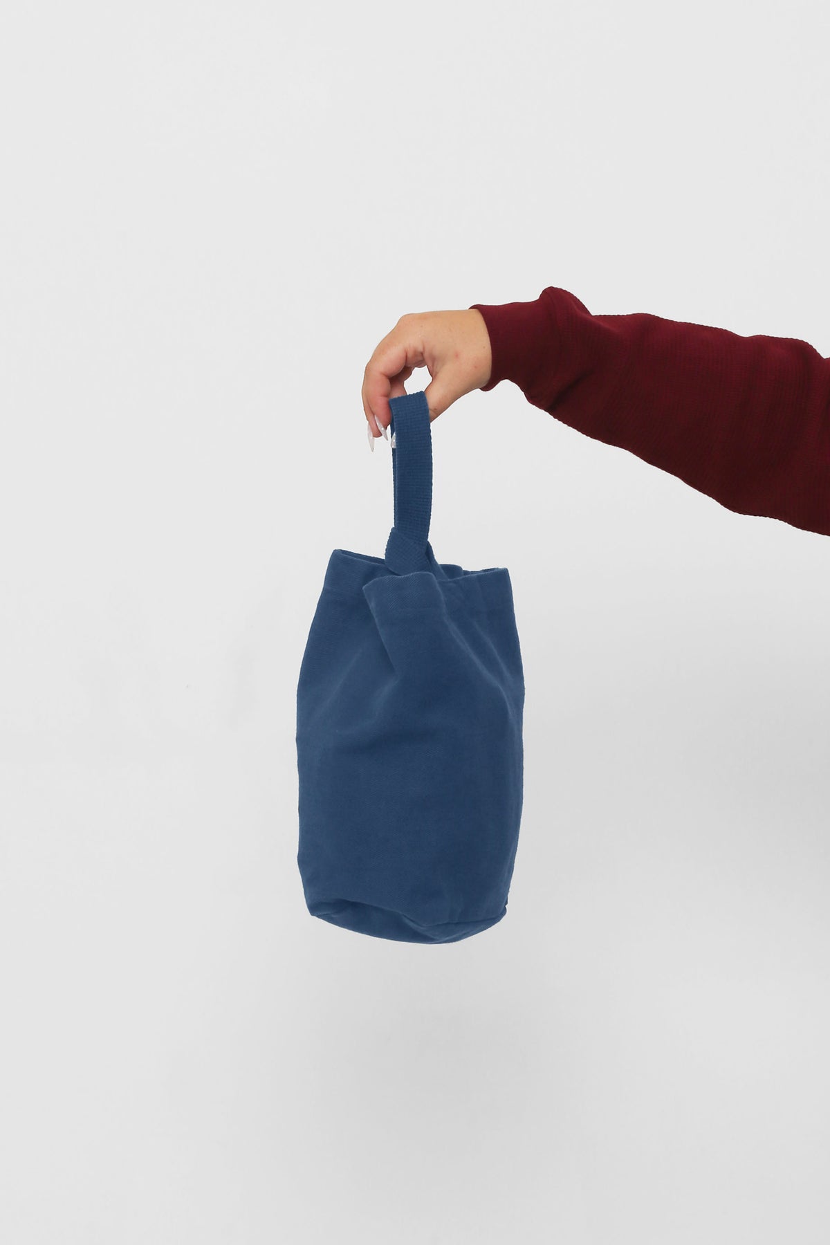 Washed Navy Loop Tote: longer strap front-facing, hand-held, showcasing gussets, depth, and stitching.