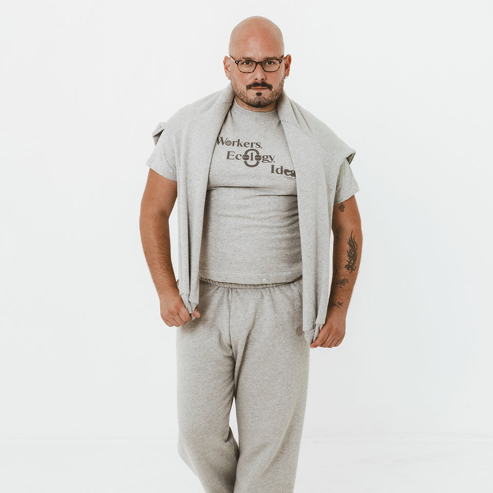 Man wearing a Heather Boxier Tee with a Heather Crewneck over his shoulders and Heather Sweatpants.