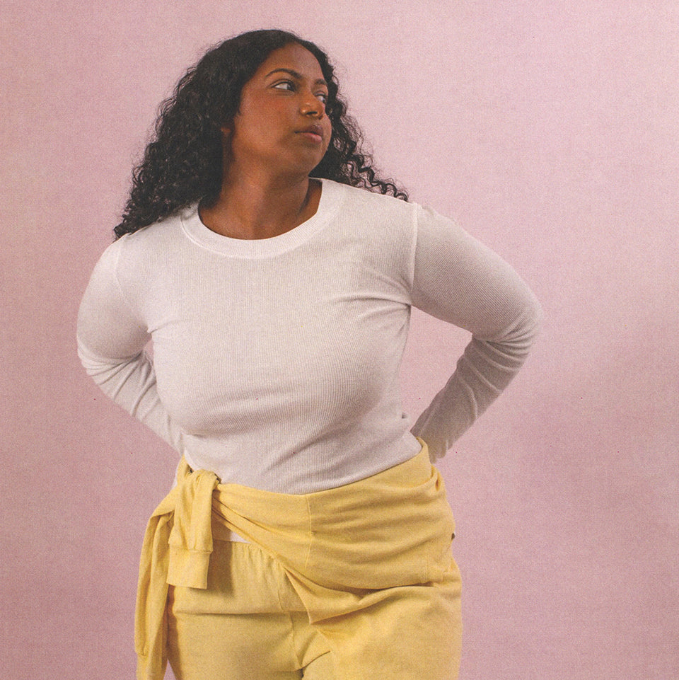 Person wearing Rib Long Sleeve in White, with a Long Sleeve Boxier Tee in Butter Yellow wrapped around her waist and Apartment Pants in Butter Yellow.
