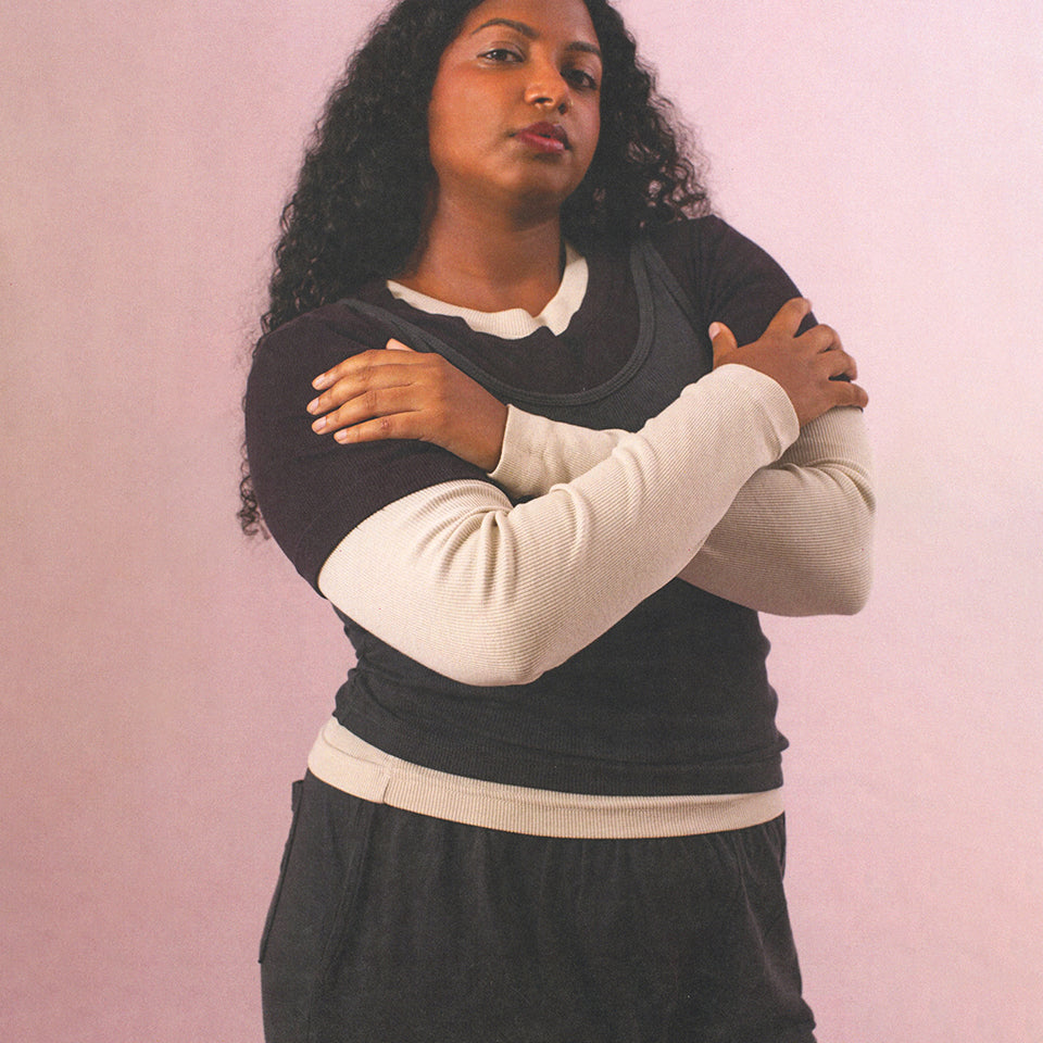 Woman with her arms crossed wearing Rib Long Sleeve in Oat, Rib Short Sleeve in Mulberry, and Rib Tank in Slate.