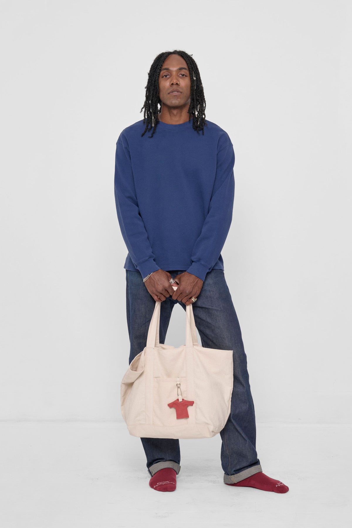 Overnight Tote held in front of model's legs for scale.