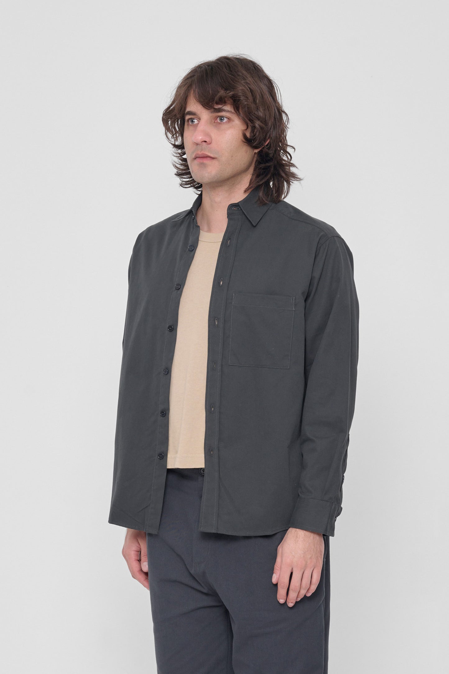 Facing 45-degrees, highlighting the shirt's sleeves. 