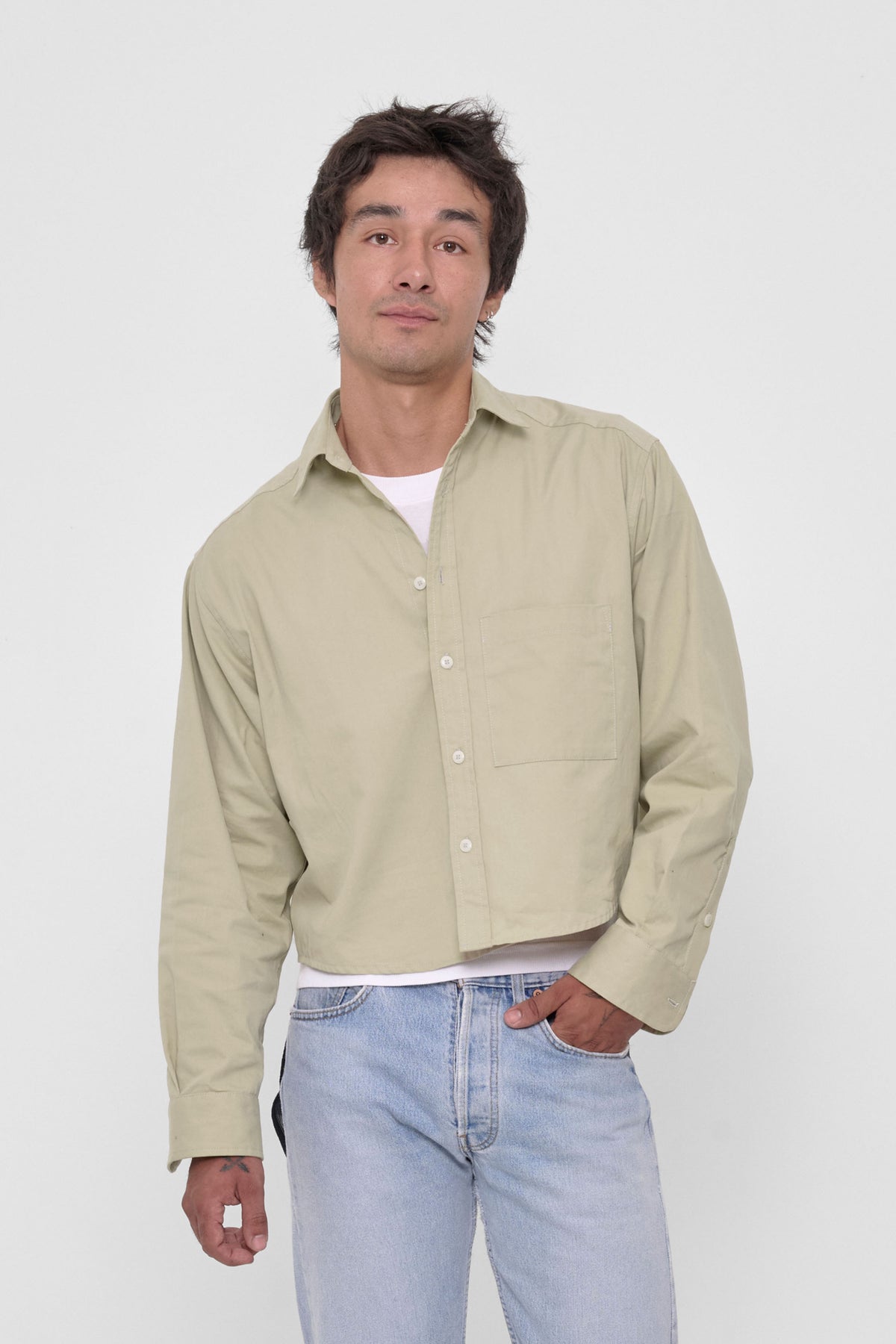 Peach Fuzz Cropped Button-Up Shirt in Oat – front view on model, layered over white tee