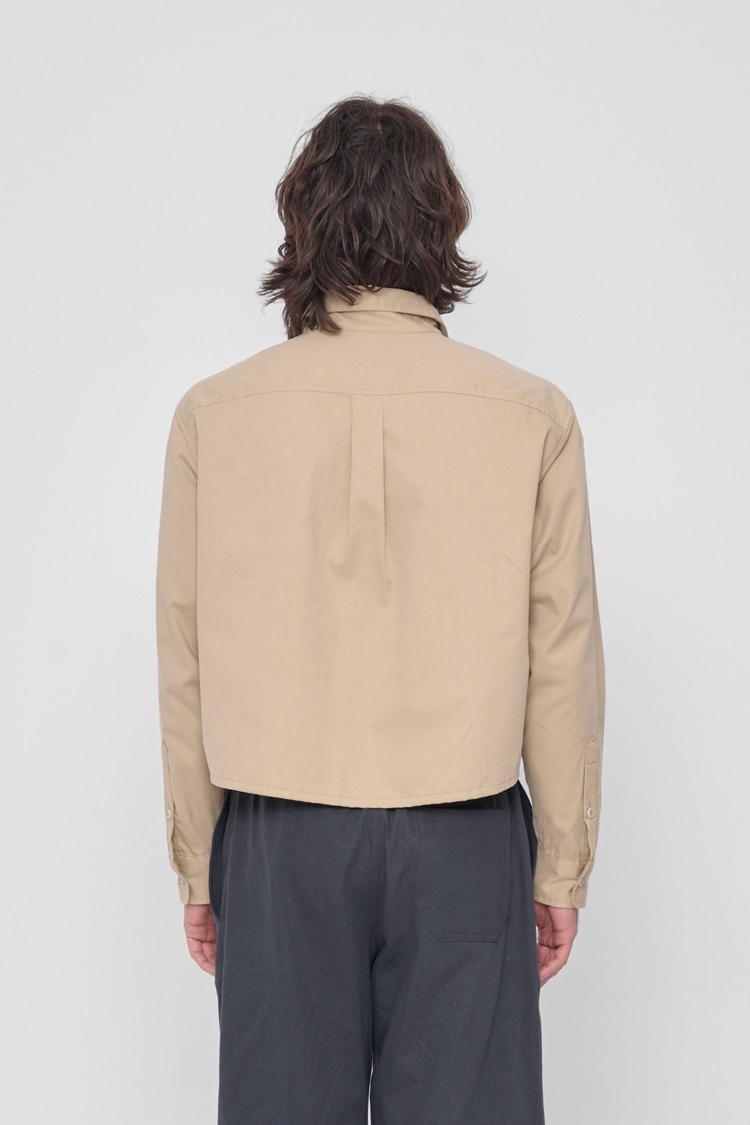 Back view highlighting box pleat at back yoke and oversized boxy fit.