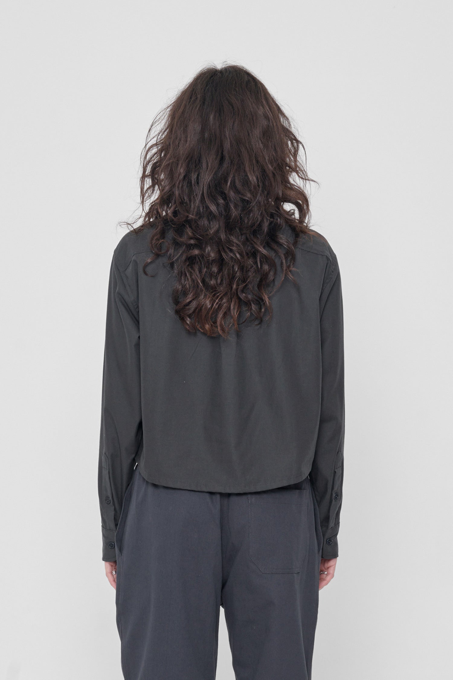 Back view highlighting box pleat at back yoke and oversized boxy fit.