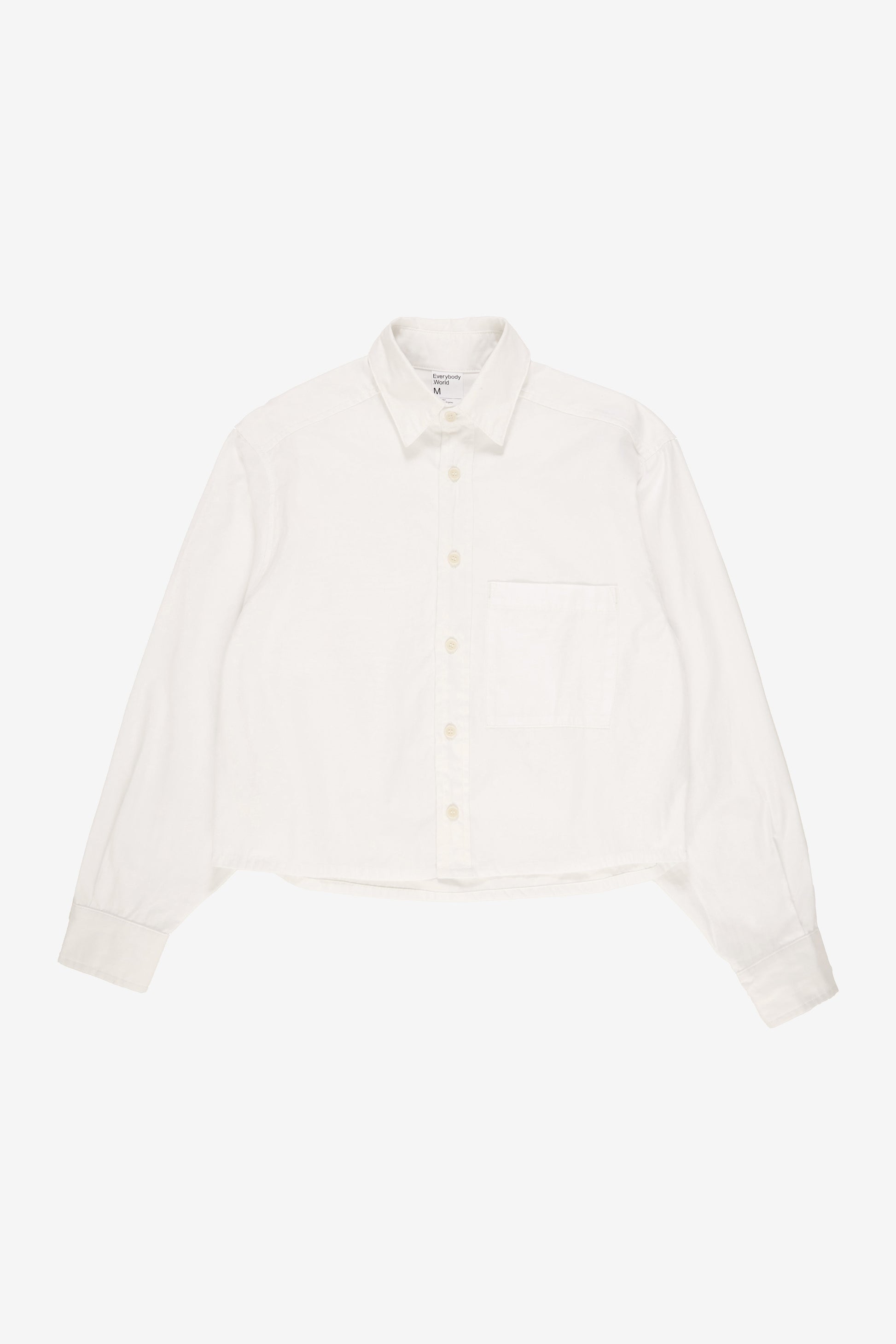 Flat lay showing boxy cropped body and straight bottom hem.