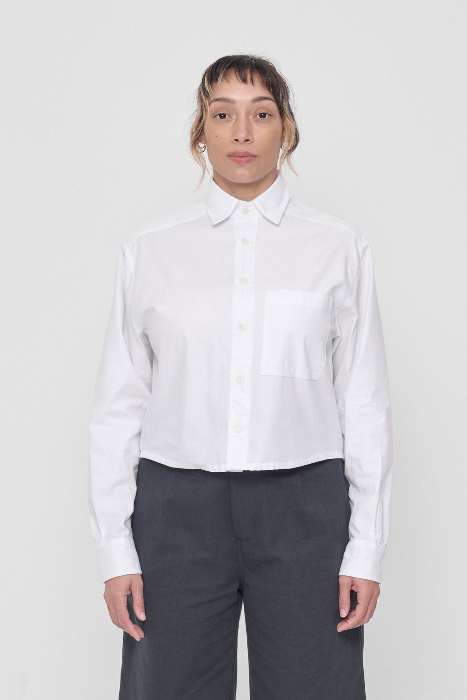 5'4" model wearing size M White Peach Fuzz Cropped Button Up Shirt. Bottom hem hits at waist. 