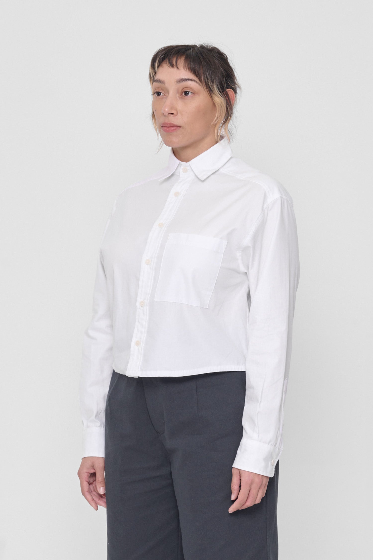 3/4 view highlighting front breast pocket and buttoned sleeve cuff. 